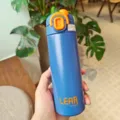 Nahaufnahme einer blauen Edelstahl Vakuum Isolierflasche mit orangenem Deckel und Sicherheitsverschluss. - 420ml / Blau