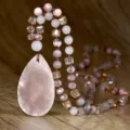 Primo piano dettagliato di una lunga collana in cristallo con grande ciondolo rosa. - N2864 Quarzo Rosa Ciondolo a Goccia Stile