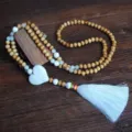 Lunga collana di perline in legno con nappina bianca e ciondolo cuore, variante pullover. - Stile Cuore