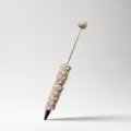 Beaded pen detail shot showing pearl and rhinestone decoration on metallic body for DIY crafts. - Champagne
