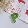 Detailansicht des grünen Strass-Buchstaben-P-Anhängers, glänzender Taschenanhänger und Schlüsselbund. - Buchstabe P