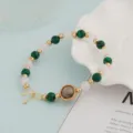 Close-up view of the beaded bracelet featuring green malachite-style and white crystal beads. - Peacock Green and White Premium Style
