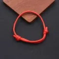 Detailed shot of a red nylon parachute cord bracelet, featuring handmade adjustable woven design. - Braided Adjustable Style (BN-0279) / Red