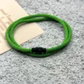 Detail of the green braided rope bracelet featuring a sleek black magnetic clasp on texture. - Double-Layer Magnetic Clasp Grass Green
