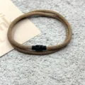 Primer plano de pulsera marrón tejida de doble capa con cierre magnético negro, detalle. - Cierre Magnético Doble Capa Caqui