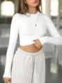 Ribbed long-sleeve crop top detail view, showcasing the slim fit crewneck design and texture. - S / Tops / White