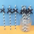 Cannucce di carta a righe bianche e nere con elegante fiocco nero per feste. - Cannucce con fiocchi di nastro a righe nere