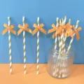 Cannucce di carta a strisce oro e bianco con fiocchi arancioni per feste e decorazione della tavola. - Cannucce a strisce oro con fiocco in nastro