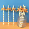 Cannucce di carta a righe gialle e bianche con fiocco arancione, variante per decorazioni. - Cannucce con fiocco in nastro a righe arancioni