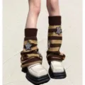 Detail shot of knitted striped leg warmers featuring sparkling sequin star patches. - One Size / Coffee Striped Stars