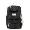 Detailansicht des schwarz-weißen Polka-Dot-Rucksacks mit dem vorderen gewebten Etikett. - Schwarz