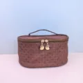 Detail view of the brown woven PU cosmetic bag, highlighting the smooth double zippers and gold pulls. - 22x16x12 CM / Caramel color