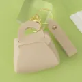 Cute leather mini handbag keychain with gold hardware, elegant bag charm detail close-up. - Off White
