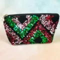 Detailed view of the sparkling sequin cosmetic bag with chevron pattern and pearl zipper charm. - Green Red Pink