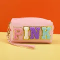 Detail shot of pink cosmetic storage bag with colorful embroidered letters and wristlet zipper. - PINK Series / 18X7X9CM / Lotus Pink