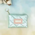 Mint green quilted coin purse detail showing soft glossy fabric, pink ruffled label, and gold hardware. - 15x11cm / Holographic Green