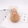 Nahaufnahme des süßen schlafenden Baby Plüsch Schlüsselanhängers mit weichem Pompom und Mütze. - Khaki