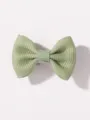 Primo piano di un fermaglio per capelli con fiocco verde chiaro, tessuto morbido per bambini. - Verde chiaro