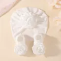 Vue rapprochée détaillée de l'élégant ensemble chapeau et chaussettes de bébé blanc floral. - Ensemble Trois Pièces Blanc (Style Infirmière)
