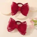 Close-up of red children's mesh bow hair ties featuring a delicate polka dot texture - 2-Piece Set / Burgundy