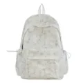 Detailed view of white schoolbag with marble texture and silver lightning bolt patterns - White