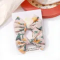 Pair of cute embroidered floral fabric bow hair clips for kids on a white display card - Floral Embroidered Bow Hair Clip (10) / 1 Piece / Light Pink