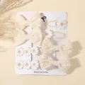 Primer plano de lazos de tela crema y pinzas para el cabello con margaritas - Juego de 8 piezas / Beige