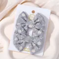 Pair of grey fabric bow hair clips with white floral embroidery on display card - Daisy Embroidered Bow (24)
