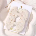 Set of two cream-colored embroidered fabric bow hair clips for kids on a white card - Embroidered Hollow Bow (33)