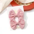 A pair of pink embroidered fabric bow hair clips for children on a white display card. - Hollow Embroidered Bow (5)