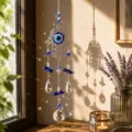 Vista dettagliata dell'acchiappasole Mano di Fatima con occhio blu e prismi di cristallo - Stile Mano di Fatima