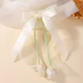 Elegant children's cream tulip bow hair clip with green streamers and satin floral accents. - Tulip Bow Ribbon Style (5533) / Creamy Yellow