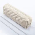 Quilted beige pencil pouch with large capacity, durable zipper closure and neat stitching. - Off White