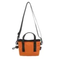Front view detail of a vibrant orange and black contrast crossbody small square bag - Orange Red