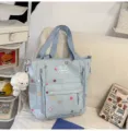 Detailed view of cute light blue canvas tote bag with star prints, front pocket and plush toy. - Tote Bag Blue With Pendant