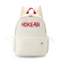 Vue de face du sac à dos scolaire crème avec broderie HDKEAN rouge et poignée supérieure - L / Blanc
