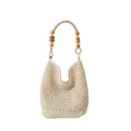 Gros plan d'un sac cabas en tricot ajouré tissé main avec poignée en perles de bois. - Blanc Cassé