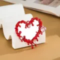 Primo piano dell'accessorio specchio cuore liquido rosso Y2K con cristalli rosa. - Rosso