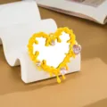 Dettaglio macro dello specchio a cuore Y2K giallo a goccia liquida con strass rosa - Giallo