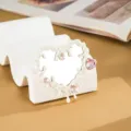 Dettaglio dello specchio a cuore liquido bianco con strass rosa brillanti. - Bianco