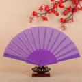 Purple folding fan with plastic frame and fabric surface for summer cooling or dancing performance. - Purple