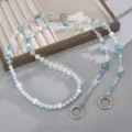 Dettaglio di un cordino per telefono in perline con fiori blu e libellule. - Catena a Tracolla Libellula Fiore Blu (K6474)