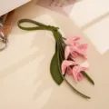 Nahaufnahme eines eleganten Taschenanhängers aus PU-Leder mit rosa-grüner Blume - 金桂花皮革挂件(K6362)