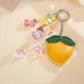 Close-up of cute PU leather peach bag charm with various printed acrylic pendants - Peach Origami Crane Pendant (K1751) / Yellow