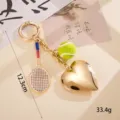 Detailweergave van de tennisracket- en hartslothanger met afmeting- en gewichtsnotaties. - Honkbal & hart hanger goud