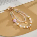 Detail view of double-strand beaded phone strap with iridescent beads and pearls - Double Chain Crown Fortune Pendant / Purple