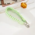 Detailansicht der handgewebten mintgrünen Nylon-Telefonkordel mit silbernen Verschlüssen - Kreuzknoten Handschlaufe / Hellgrün (K6608)