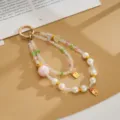 Detail view of a colorful double-strand beaded phone charm with crown and gold lucky tags. - Double Chain Crown Fortune Pendant / Pink