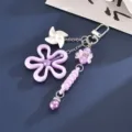 Detailaufnahme eines lila hohlen Blumen-Schlüsselanhängers mit weißem Windrad-Anhänger - Anhänger (K6531) / Hohlblume Und Windmühle Anhänger Lila