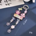 Detailed macro view of a candy-colored beaded bag charm with heart and butterfly shapes - Pink